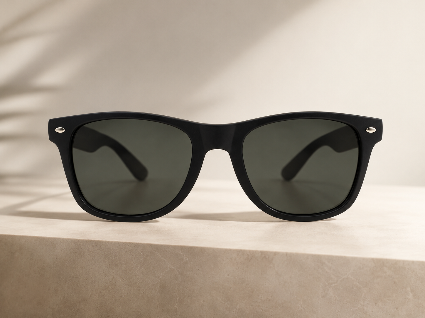 ShadesLab matte-black sunglasses resting on a sunlit stone ledge